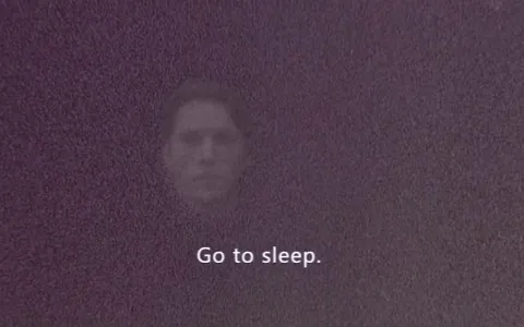 Se intuye un rostro difuminado tras una capa de color granate con el texto en inglés Go to sleep en letras blancas delante
