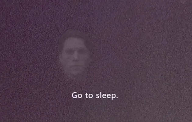 Se intuye un rostro difuminado tras una capa de color granate con el texto en inglés Go to sleep en letras blancas delante