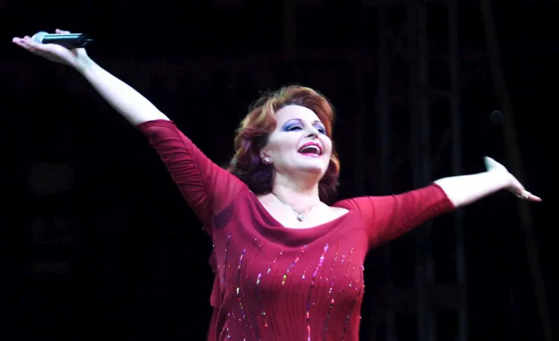 Cantante Rocío Durcal con los brazos abiertos hacia el público