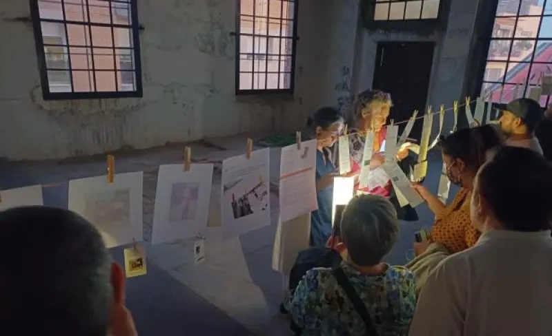 personas cuelgan folios ilsutrados en una cuerda de tender con pinzas