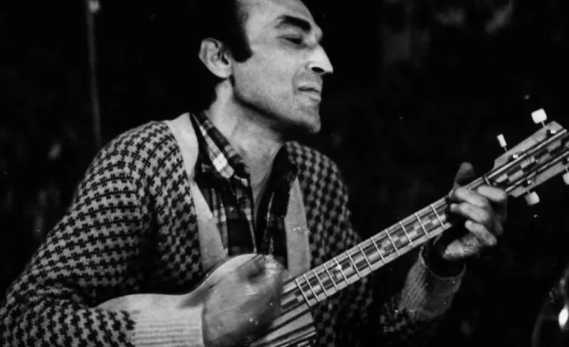 FOTO EN BLANCO Y NEGRO DE un hombre tocando la guitarra