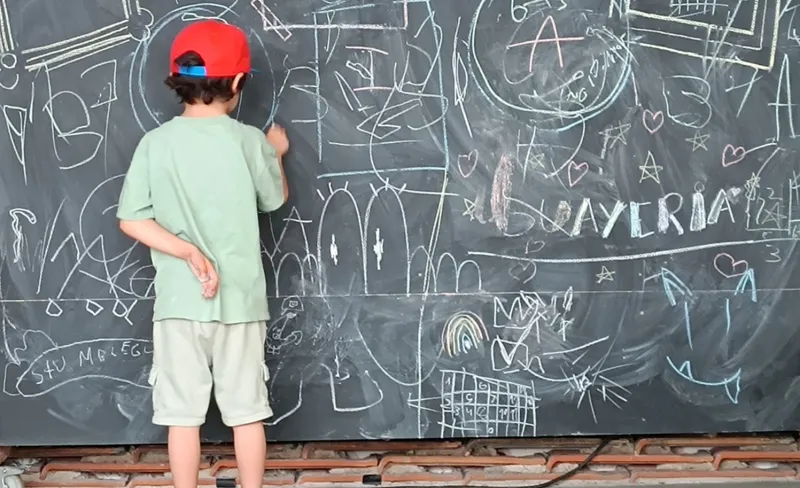 niño pintando en pizarra