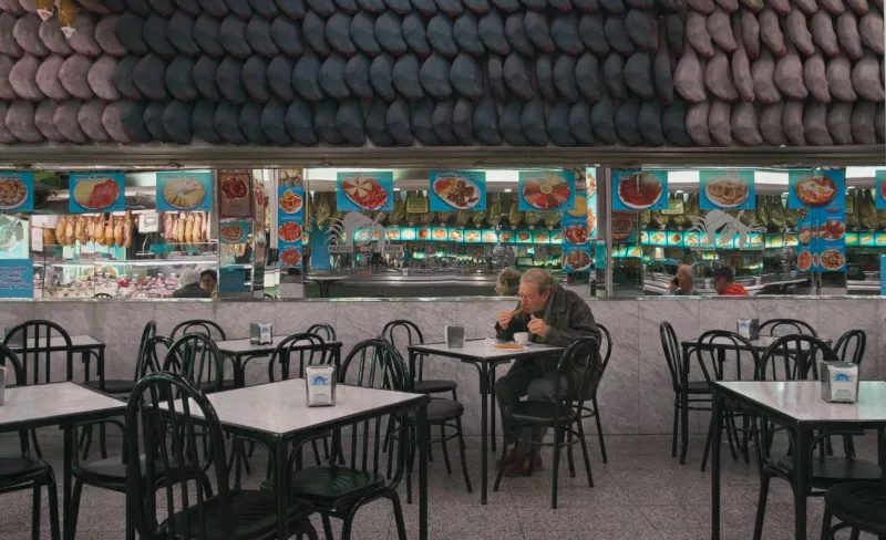 Señor comiendo churros en cafetería de Madrid