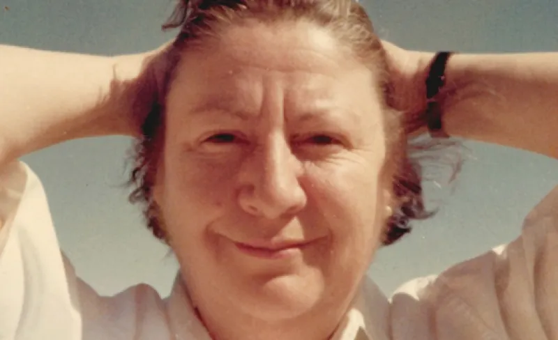 Mujer sonríe con las manos tras la nuca