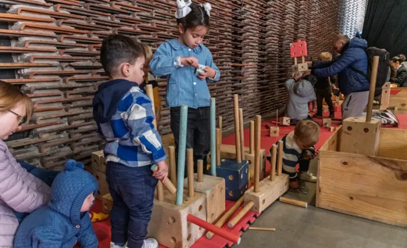 niñas y niños juegan con piezas de madera