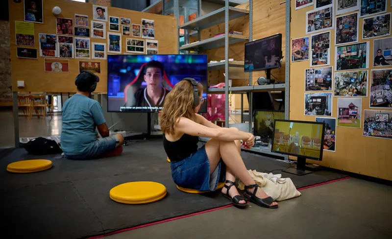 Chica y chico sentados en el suelo observan obras de arte