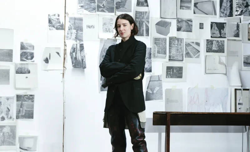 Mujer artista posa junto a su obra