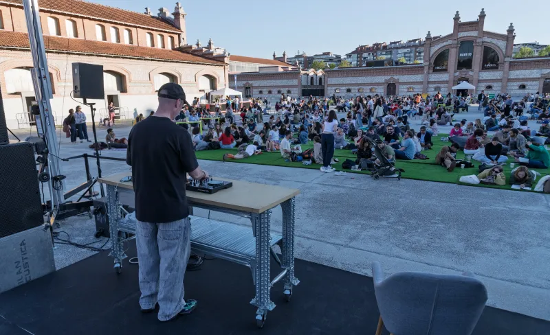 DJ pinchando ante gente sentada en una plaza