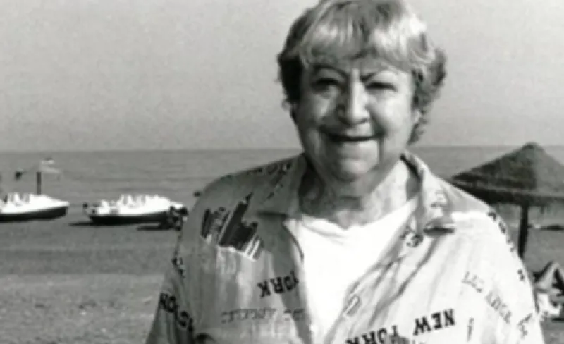 Fotografía de Gloria Fuertes en blanco y negro con barcos de fondo