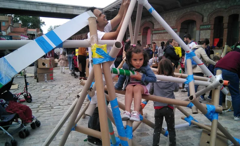 NIÑOS Y NIÑAS JUGANDO CON PIEZAS DE CARTÓN