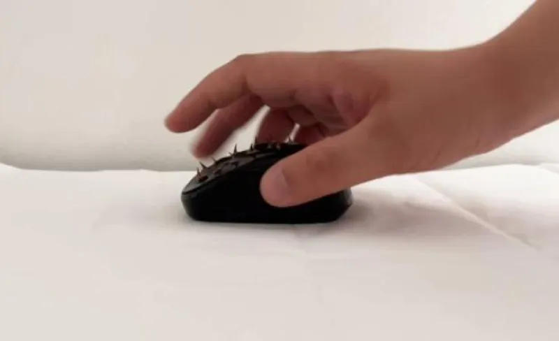 Mano usando un ratón de ordenador con pinchos