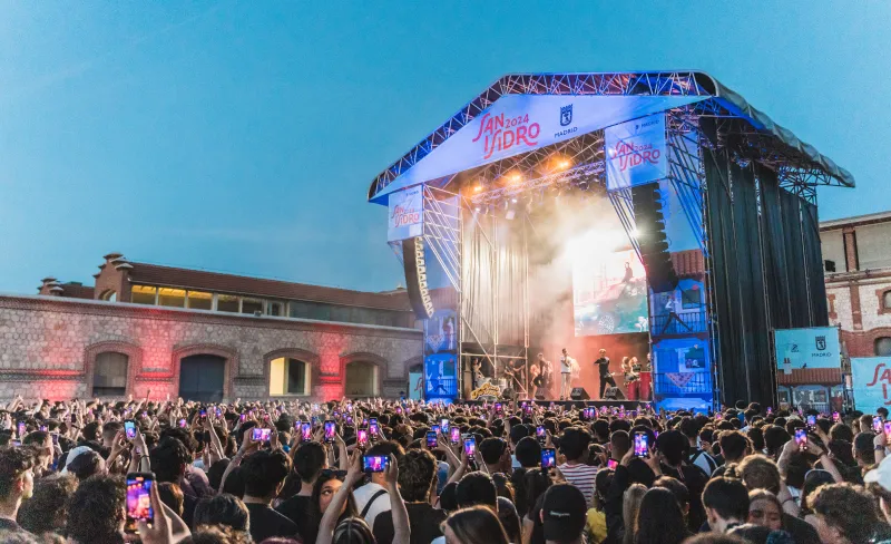 Gente frente a un escenario asiste a un concierto
