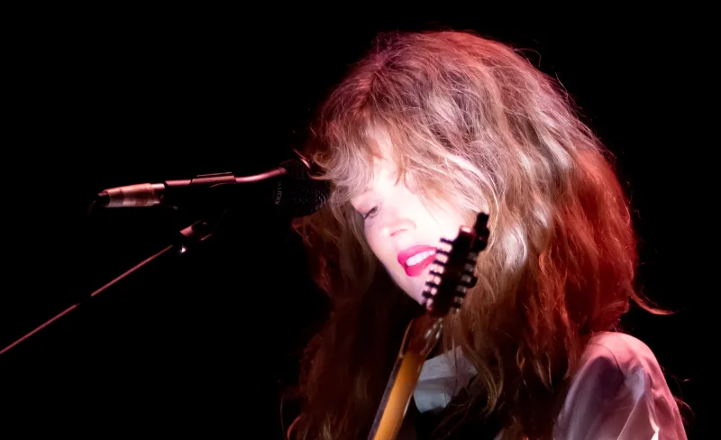 Mujer rubia toca la guitarra eléctica