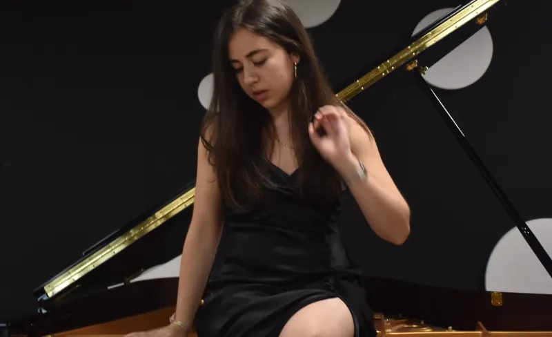 Chica sentada sobre un piano