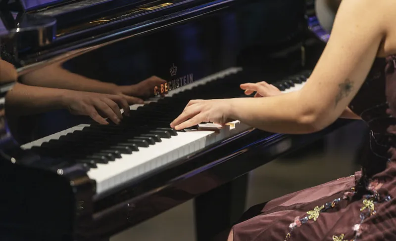 manos de mujer tocando un piano