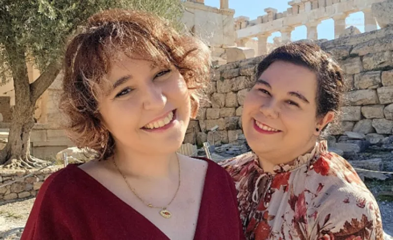 Dos mujeres miran a cámara sonrientes