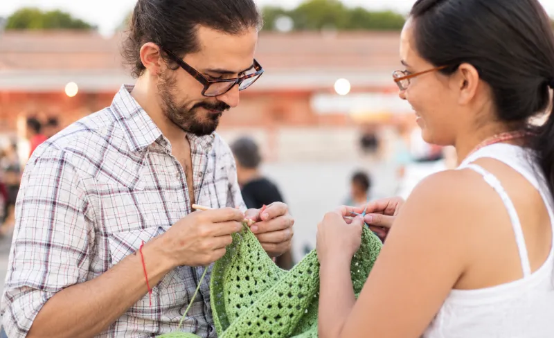 Pareja tejiendo al aire libre