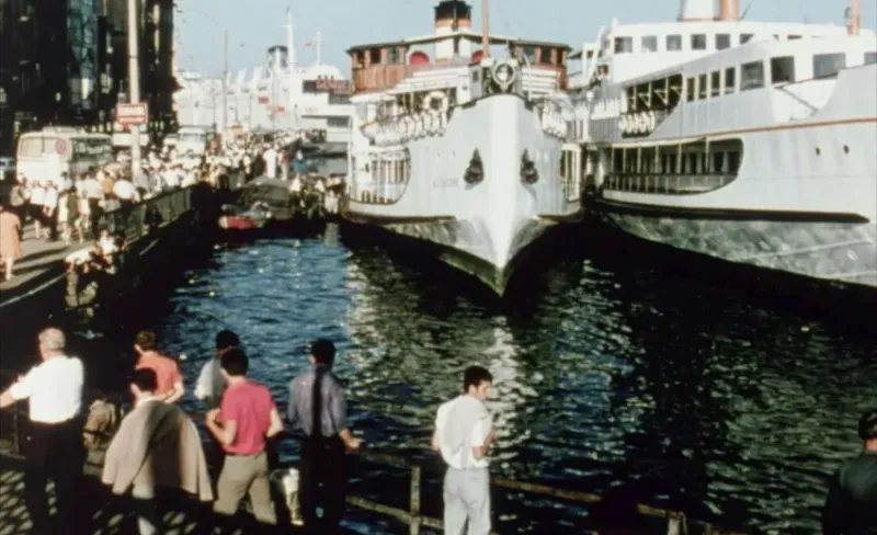 Gente observa un barco atracado en un puerto