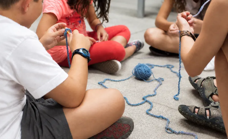 Niñas y niños juegan con hilos