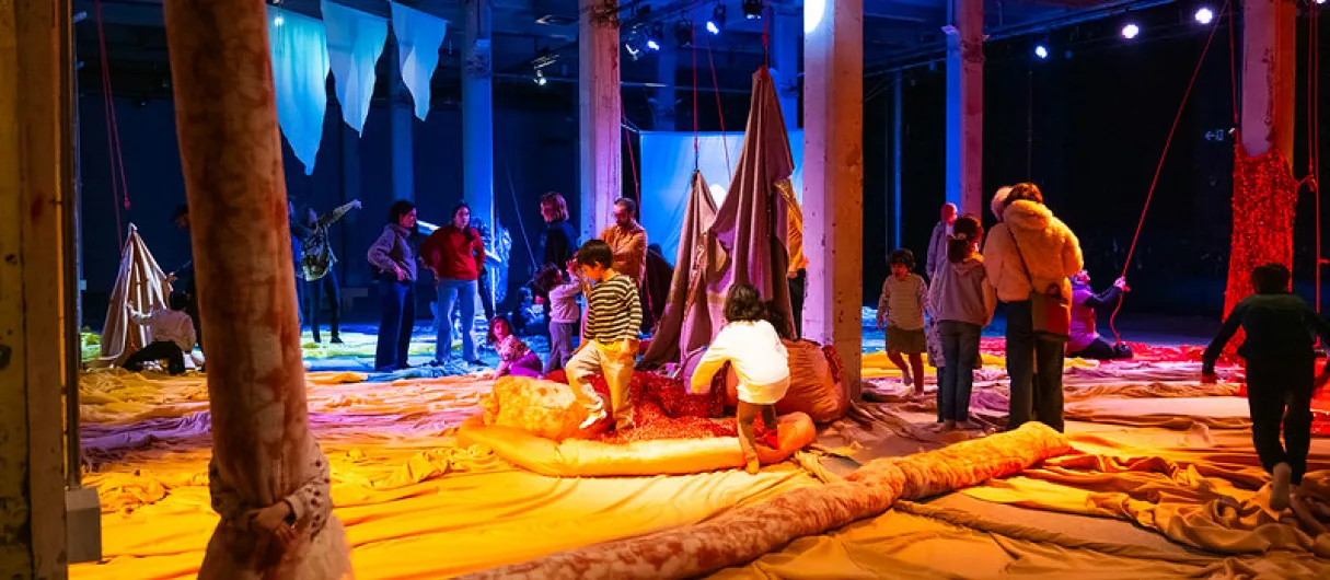 Niños y niñas jugando con cojines y otras piezas de tela