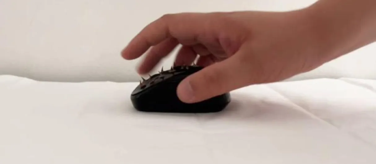 Mano usando un ratón de ordenador con pinchos