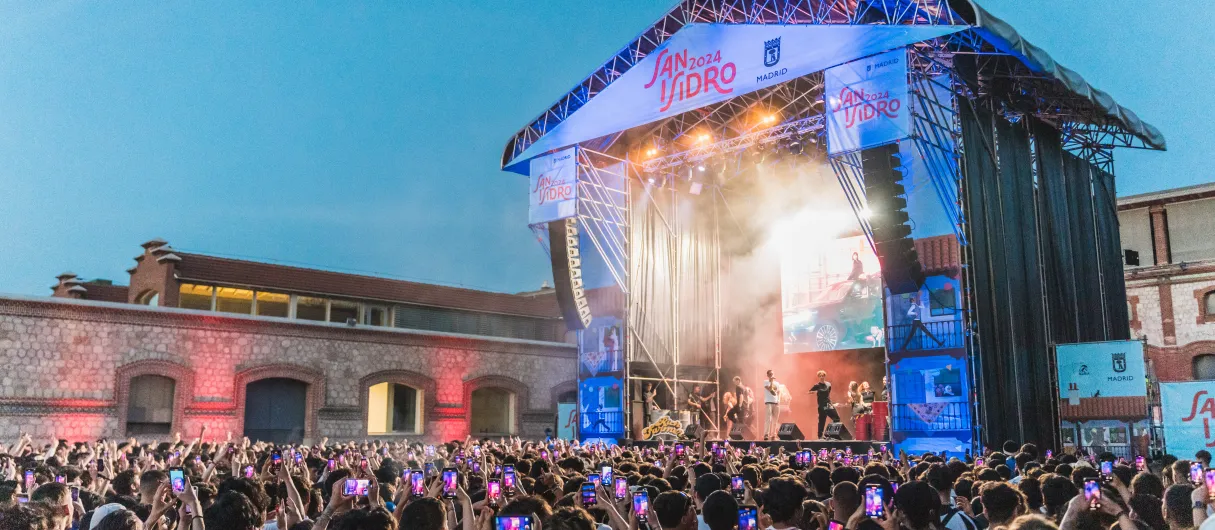 Gente frente a un escenario asiste a un concierto