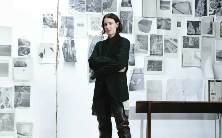 Mujer artista posa junto a su obra