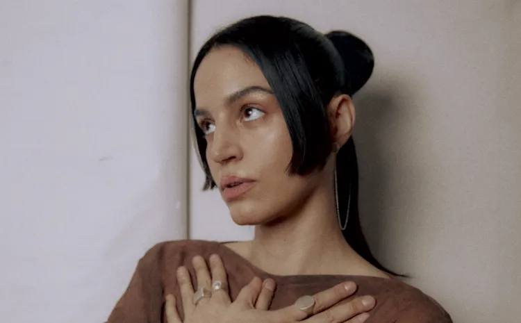 Chica con las manos cruzadas sobre el pecho