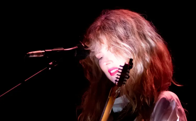 Mujer rubia toca la guitarra eléctica