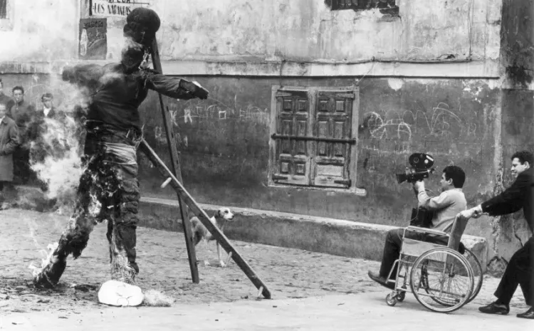Una persona en una silla de ruedas filma la quema de un muñeco en la calle