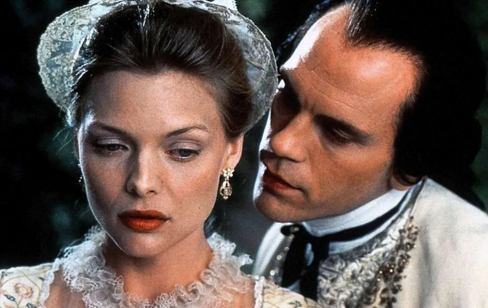 Un hombre susurra al oído de una mujer vestidos de época