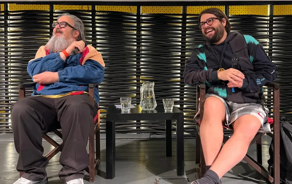 Dos hombres sentados ríen