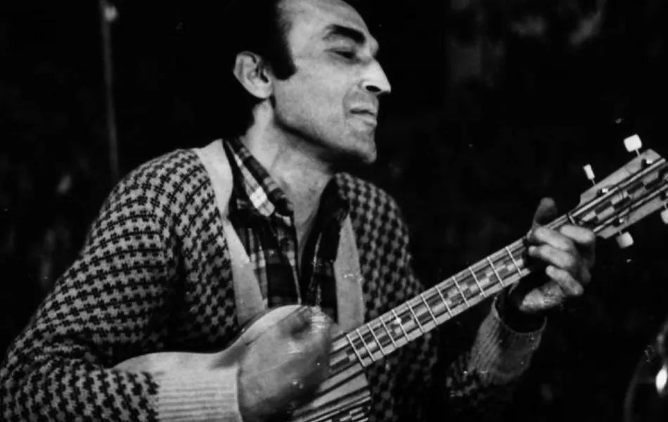 FOTO EN BLANCO Y NEGRO DE un hombre tocando la guitarra