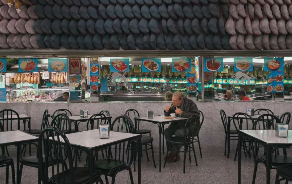 Señor comiendo churros en cafetería de Madrid