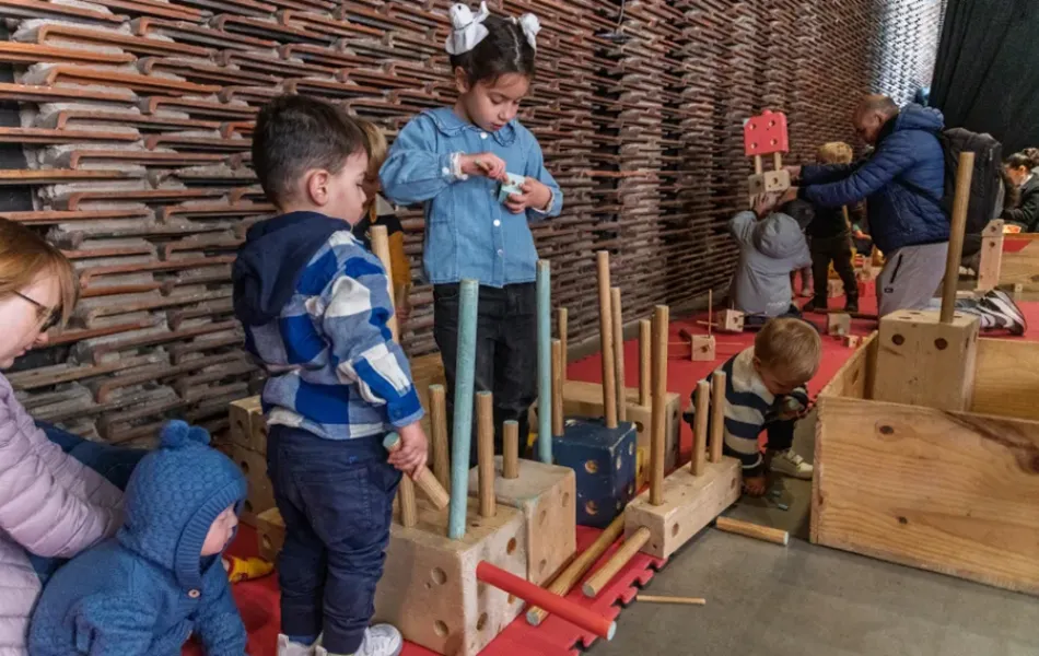 niñas y niños juegan con piezas de madera
