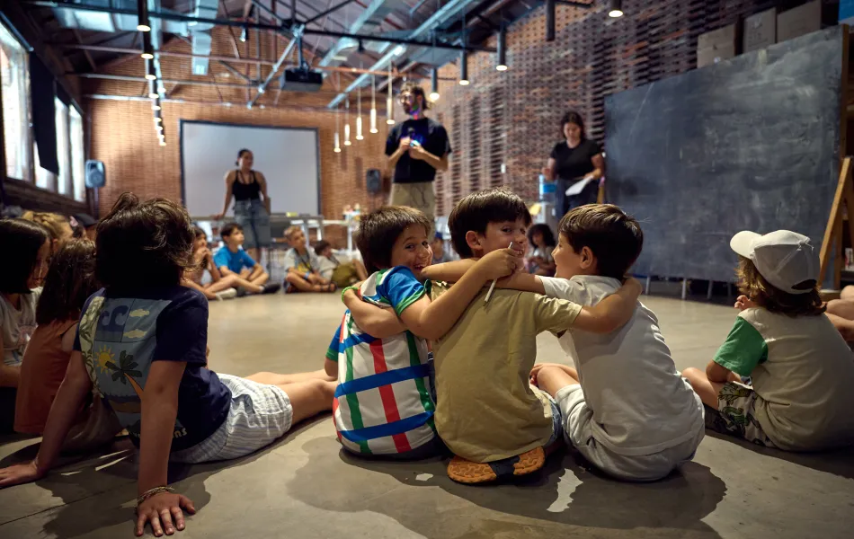 Niños abrazados y sentados de espaldas a cámara