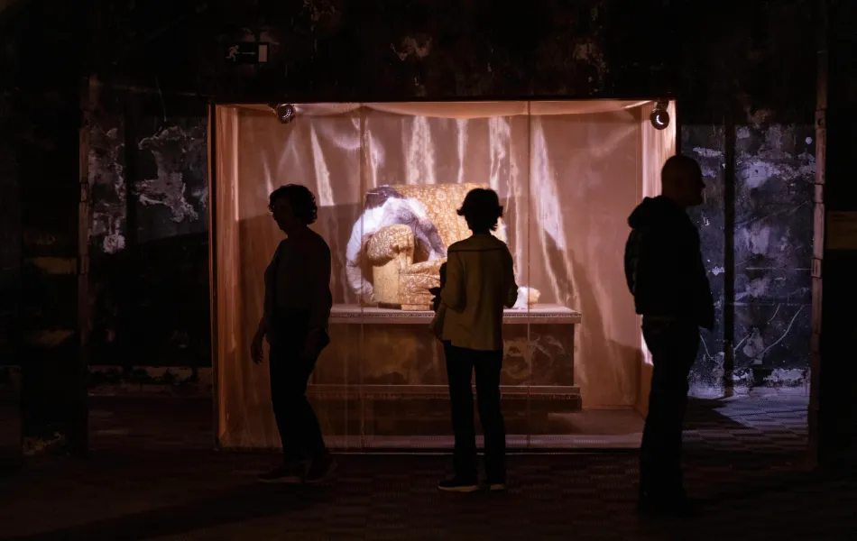 Siluetas contemplan una obra de arte iluminada