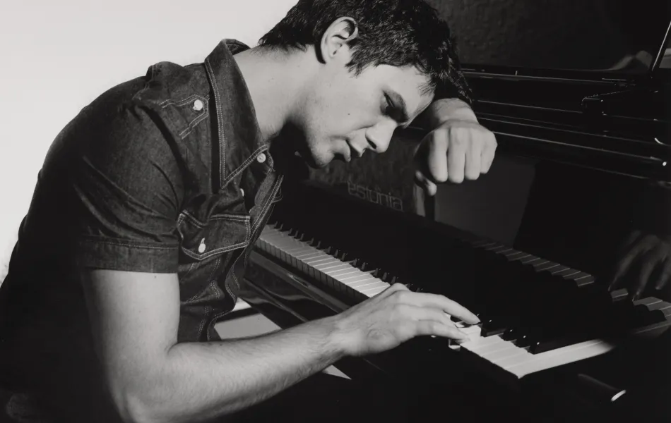 Chico toca el piano apoyado en él