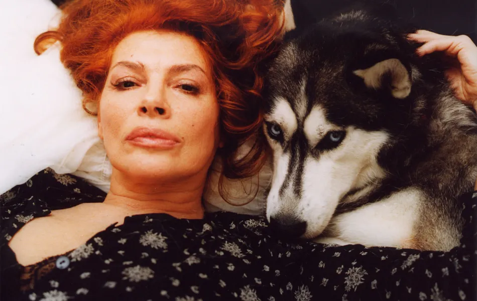 Rostro de mujer tumbada junto al de un perro husky