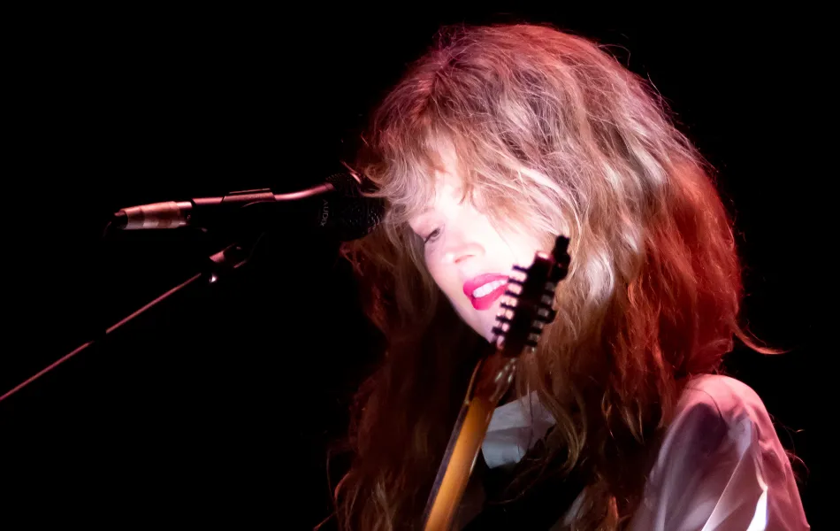 Mujer rubia toca la guitarra eléctica