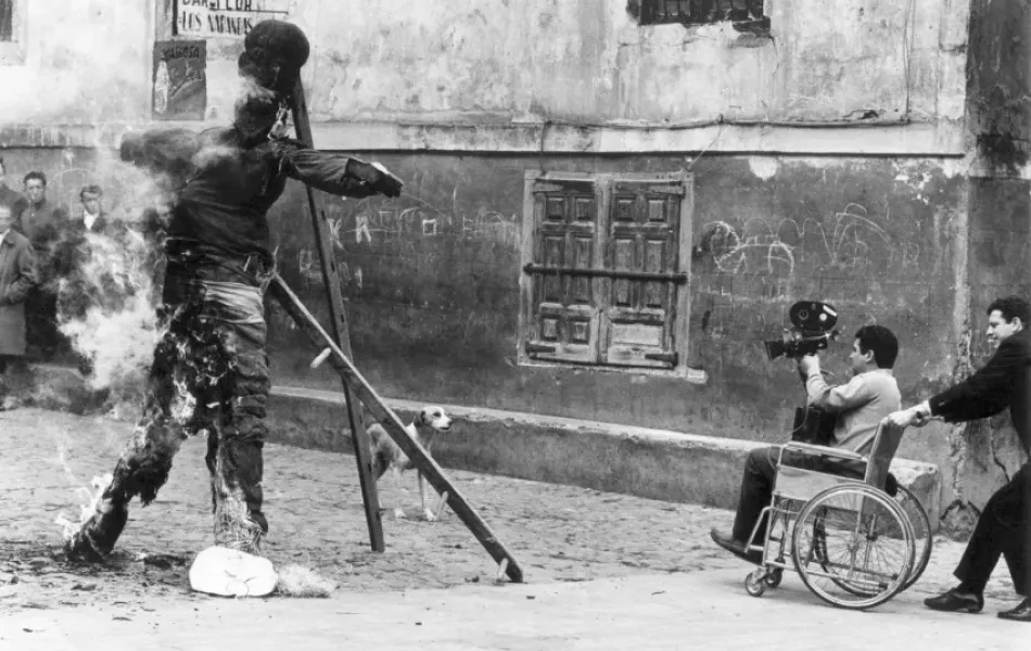 Una persona en una silla de ruedas filma la quema de un muñeco en la calle