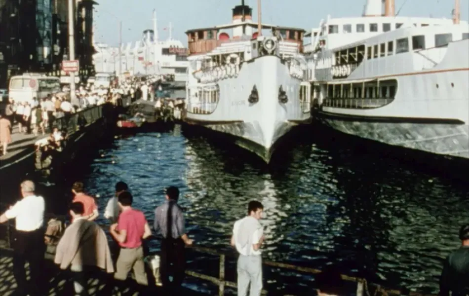 Gente observa un barco atracado en un puerto