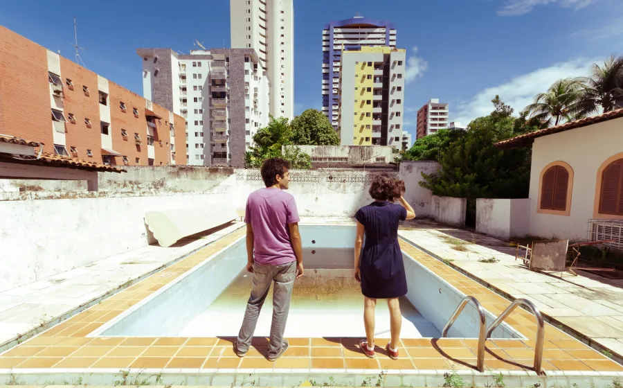 Una pareja observa una piscina vacía