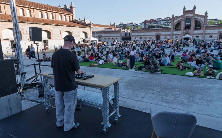 DJ pinchando ante gente sentada en una plaza