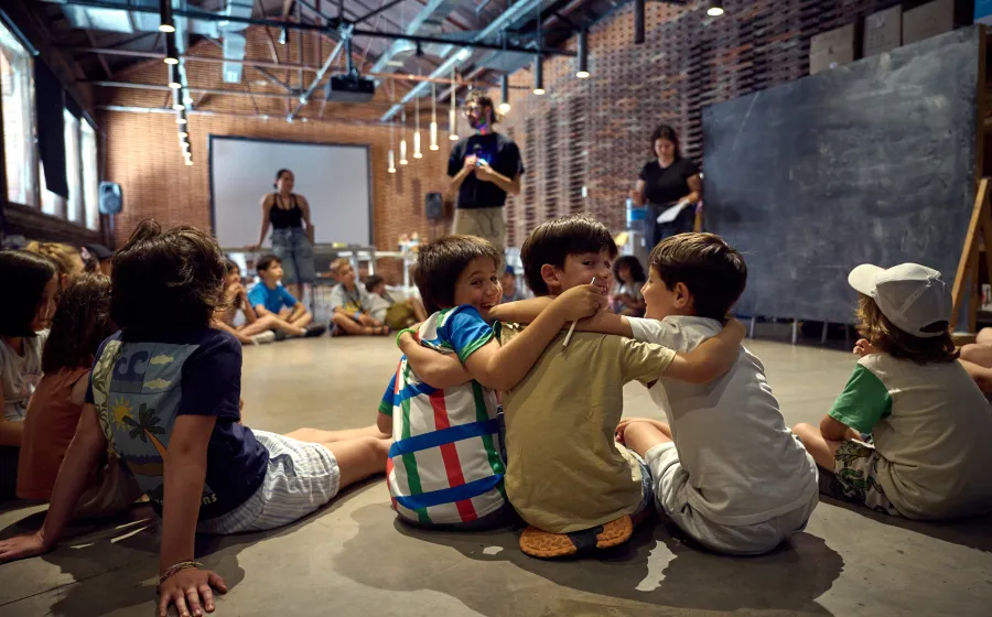 Niños abrazados y sentados de espaldas a cámara