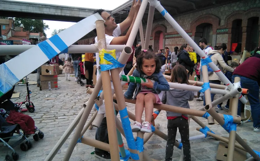 NIÑOS Y NIÑAS JUGANDO CON PIEZAS DE CARTÓN