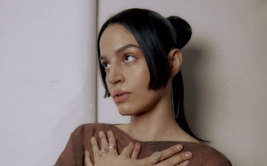 Chica con las manos cruzadas sobre el pecho