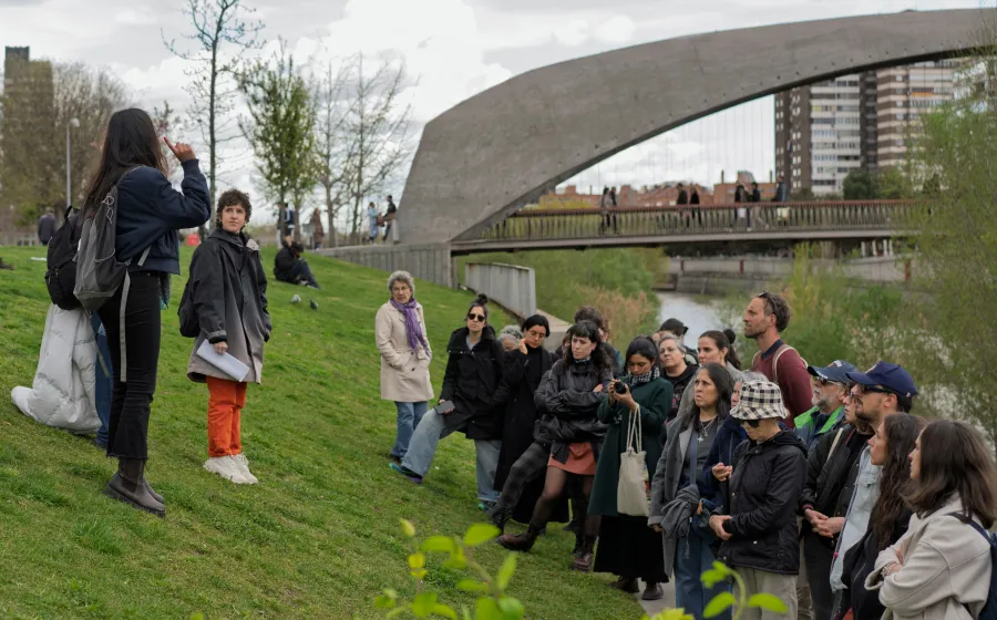 Grupo de gente atiende a una mujer que les habla en un parque