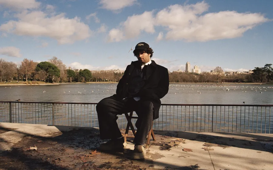 Chico sentado en una silla al lado de un estanque