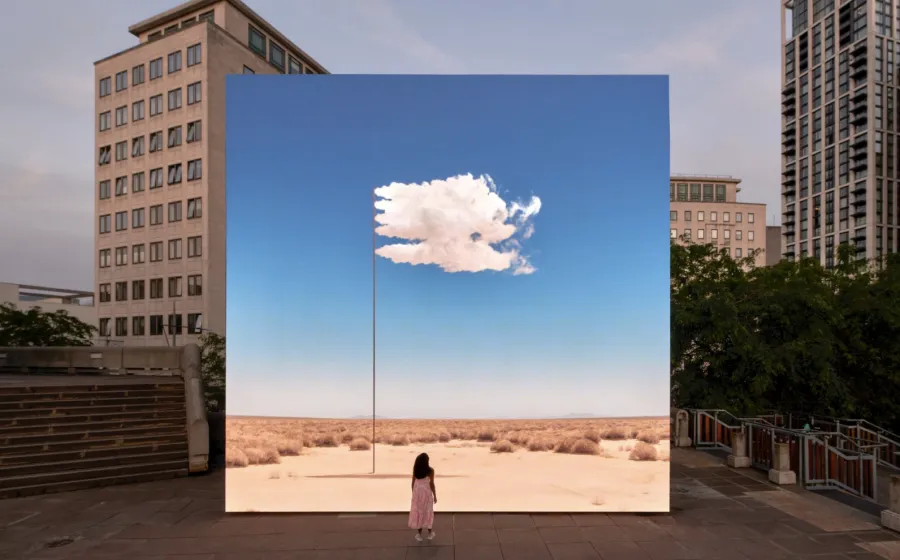 Mujer mira un panel con un paisaje dentro de una ciudad